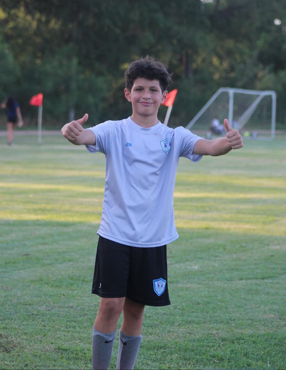 Un jugador sonriendo con los pulgares arriba frente a la portería