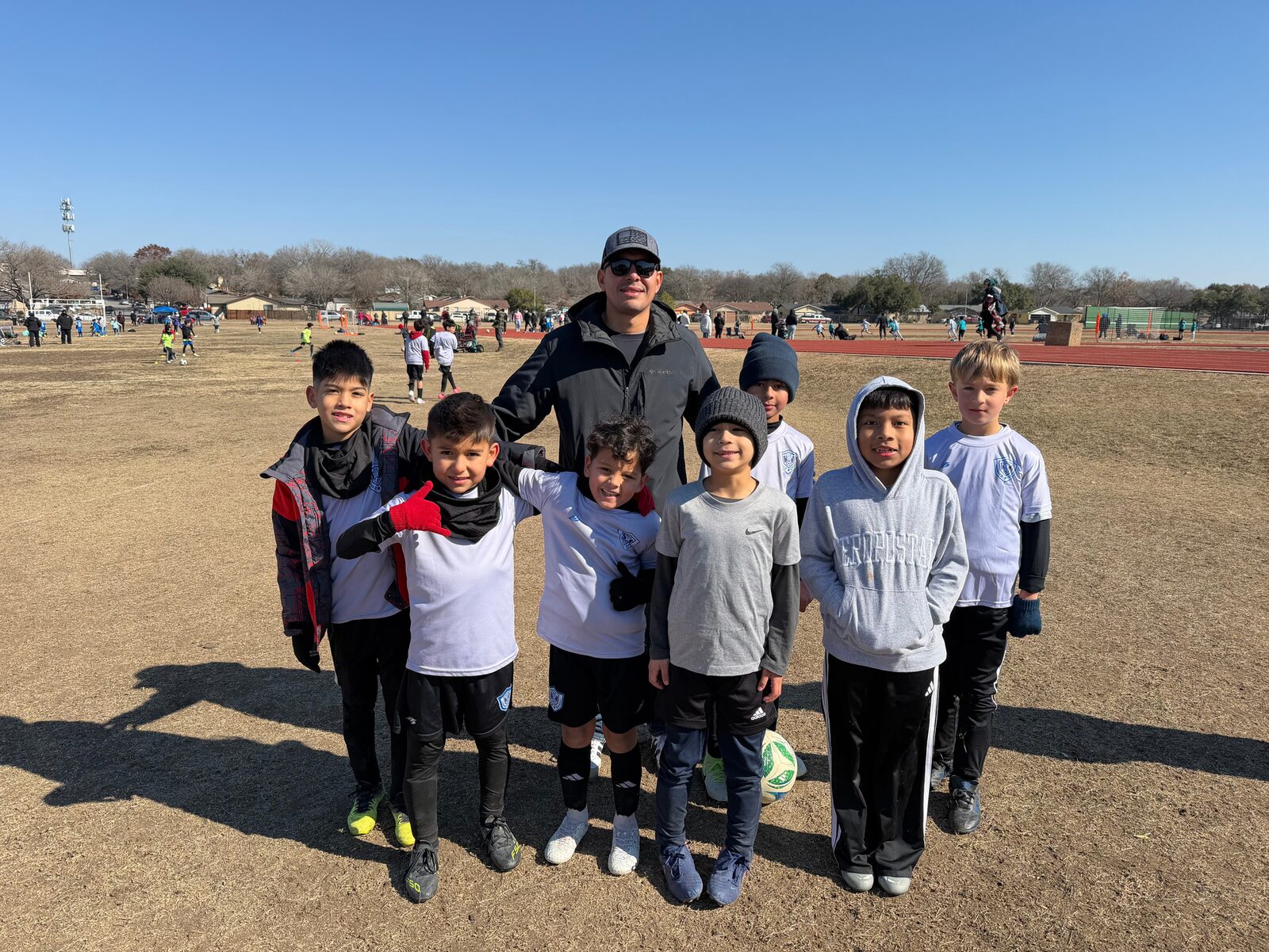 El equipo de la academia con su entrenador en el campo