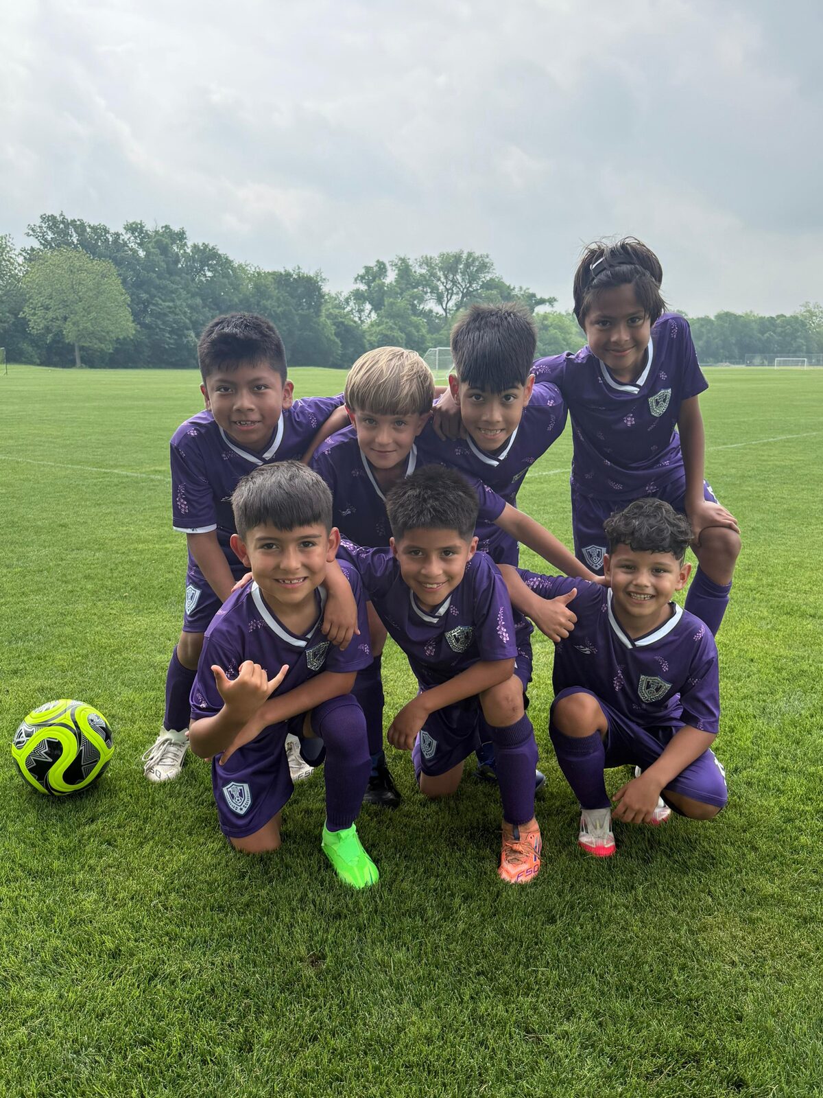 Academy players posing on the field before a match